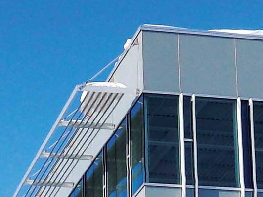 Photo of a building with large architectural sunshades, highlighting potential snow accumulation areas.